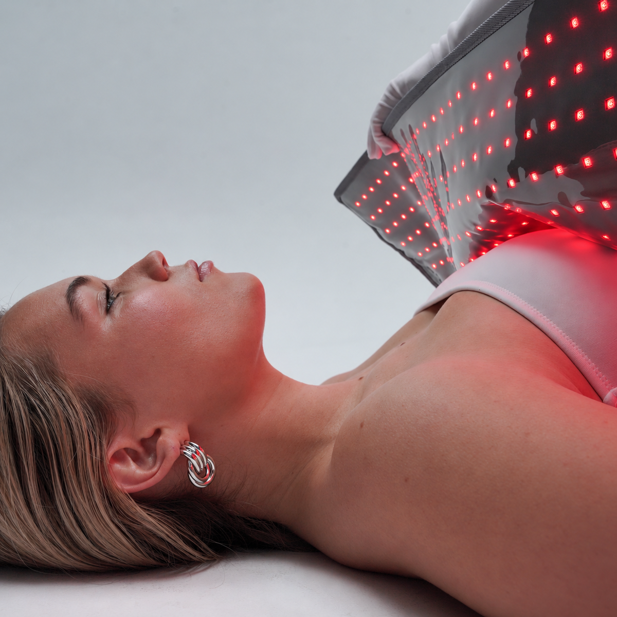 A person holding the illuminated Beam Blanket during a personal-care routine